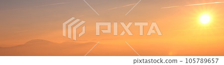 Banner sunset over mountains, yellow sun in cloudy haze Banner sunset over mountains, yellow sun in cloudy haze 105789657