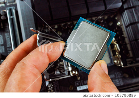 Assembly process of desktop computer involves technician plugging CPU into motherboard socket 105790889