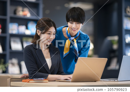 兩位女商人一邊看著筆記本電腦屏幕一邊交談 兩位女商人一邊看著筆記本電腦屏幕一邊交談 105790923