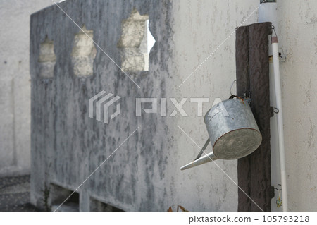 white wall and tin watering can white wall and tin watering can 105793218