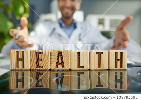 the doctor folded the word healthy from wooden cubes on the table in the hospital 105793595