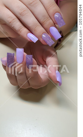 Manicure and nail extension with acrylic and gel. The design is made with shiny gel polishes. 105794844