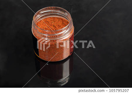 Variety of spices on a dark background in a glass bowl. Enhancement of taste. 105795207