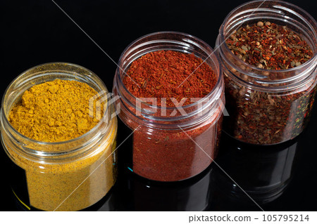 Variety of spices on a dark background in a glass bowl. Enhancement of taste. 105795214