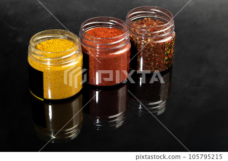 Variety of spices on a dark background in a glass bowl. Enhancement of taste. 105795215