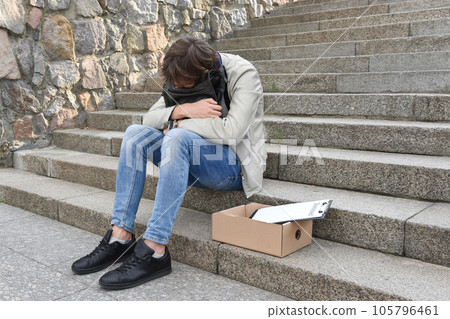 Unemployment and layoffs concept. An employee of the company, having lost his job Unemployment and layoffs concept. An employee of the company, having lost his job 105796461