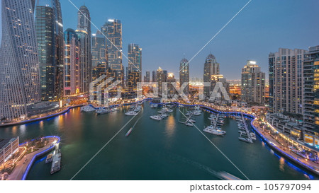 Dubai marina tallest skyscrapers and yachts in harbor aerial day to night timelapse. 105797094