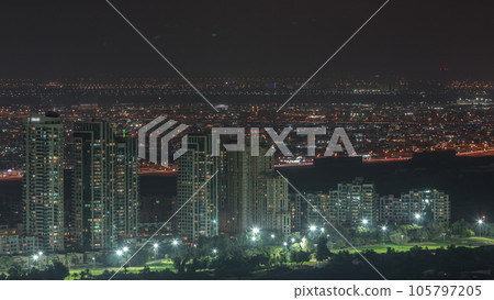 Moon rising over greens and al barsha heights district area night from Dubai marina. 105797205