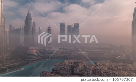 Aerial view morning fog covered Dubai International Financial Centre district timelapse 105797307