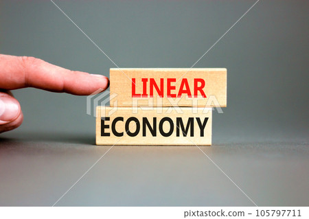 Linear economy symbol. Concept words Linear economy on beautiful wooden block. Beautiful grey table grey background. Businessman hand. Business linear economy concept. Copy space. Linear economy symbol. Concept words Linear economy on beautiful wooden block. Beautiful grey table grey background. Businessman hand. Business linear economy concept. Copy space. 105797711