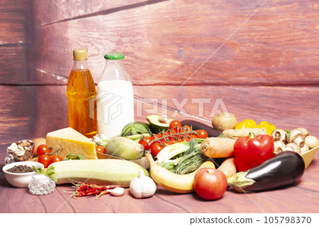 Healthy food selection with fruits,vegetables,cheese,nuts, milk,spices,olive oil on wooden background. 105798370