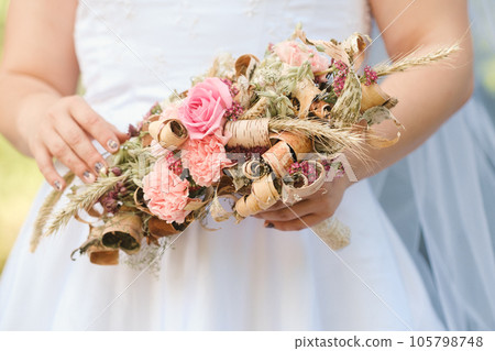 The bride holds her wedding bouquet in her hands 105798748