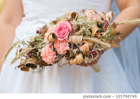 The bride holds her wedding bouquet in her hands The bride holds her wedding bouquet in her hands 105798749