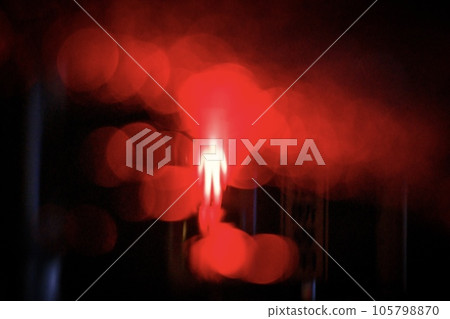 A red traffic light mark reflected in a puddle after rain 105798870