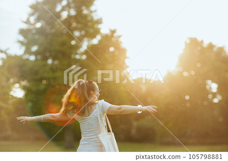 happy young woman in white shirt with tote bag 105798881