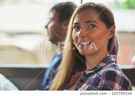 Candid portrait - young woman in shirt sitting in the bus, smiling, blurred man behind her, detail on her face Candid portrait - young woman in shirt sitting in the bus, smiling, blurred man behind her, detail on her face 105799108