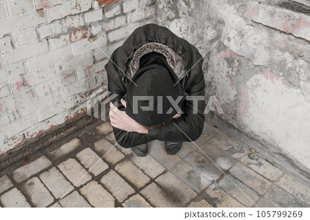 A teenager sits alone after using drugs and alcohol in an abandoned house. Addiction concept A teenager sits alone after using drugs and alcohol in an abandoned house. Addiction concept 105799269