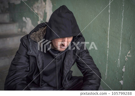 Man in the hood experiencing a drug addiction crisis. Unemployed 105799288