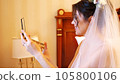 portrait. beautiful bride in white veil holding a mirror in her hands, looking at herself in the mirror, smiling. the bride is preparing for the wedding. 105800106