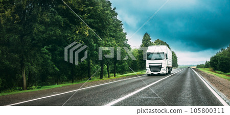 Truck Tractor Unit, Prime Mover, Traction Unit In Motion On Road, Freeway. Asphalt Motorway Highway Against Background Of Forest Landscape. Business Transportation And Trucking Industry Truck Tractor Unit, Prime Mover, Traction Unit In Motion On Road, Freeway. Asphalt Motorway Highway Against Background Of Forest Landscape. Business Transportation And Trucking Industry 105800311