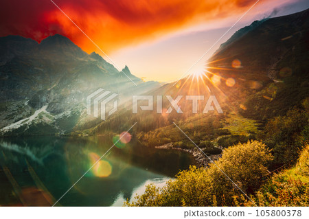 Tatra National Park, Poland. Famous Mountains Lake Morskie Oko Or Sea Eye Lake In Summer Evening. Beautiful Sunset Sun Sunshine Sunbeams Above Tatras Lake Landscape Tatra National Park, Poland. Famous Mountains Lake Morskie Oko Or Sea Eye Lake In Summer Evening. Beautiful Sunset Sun Sunshine Sunbeams Above Tatras Lake Landscape 105800378