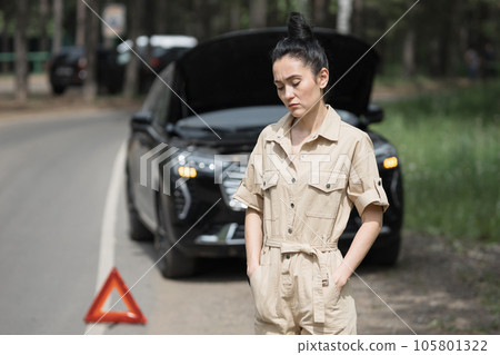 Woman calls car service to fix broken engine on roadside Woman calls car service to fix broken engine on roadside 105801322