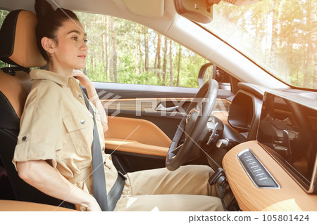 Black-haired woman fastens seat belt taking care of safety 105801424