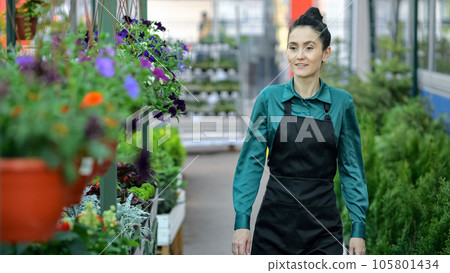 Young woman walks among shelves in flower plants department 105801434