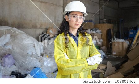 Black-haired woman in hardhat at waste sorting plant 105801463