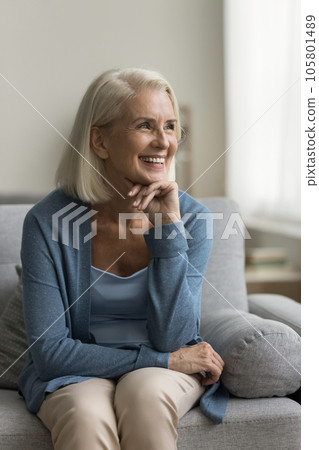 Happy pretty old mature woman relaxing on home couch Happy pretty old mature woman relaxing on home couch 105801489