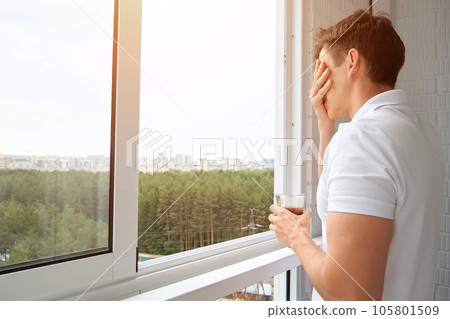 Man drinks cup of coffee on balcony overlooking forest Man drinks cup of coffee on balcony overlooking forest 105801509