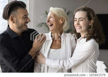 Happy elderly mom and adult son and daughter hugging Happy elderly mom and adult son and daughter hugging 105801579