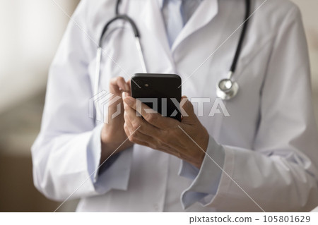 Cropped shot of doctor in uniform coat using medial application 105801629