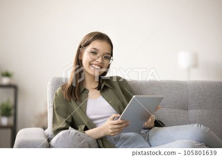 Cheerful pretty teen schoolgirl in eyeglasses doing school homework 105801639