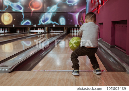 little child boy playing bowling in club 105803489