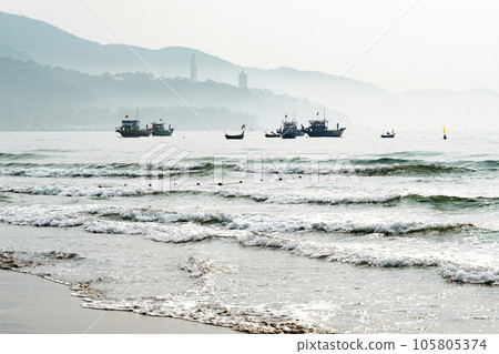 Boats floating near the beach besides the mountain in the brilliant dawn Boats floating near the beach besides the mountain in the brilliant dawn 105805374