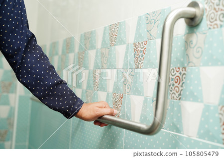 Asian woman patient use toilet support rail in bathroom, handrail safety grab bar, security in nursing hospital. Asian woman patient use toilet support rail in bathroom, handrail safety grab bar, security in nursing hospital. 105805479