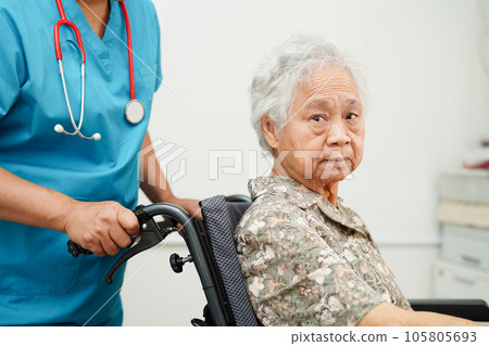 Caregiver help Asian elderly woman disability patient in nursing hospital, medical concept. Caregiver help Asian elderly woman disability patient in nursing hospital, medical concept. 105805693