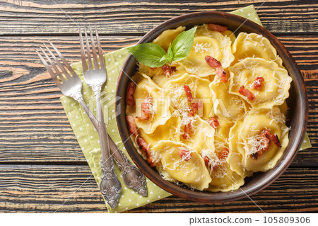 Fresh egg pasta Girasoli sunflower shaped with cheese, basil and bacon on plate. Horizontal top view Fresh egg pasta Girasoli sunflower shaped with cheese, basil and bacon on plate. Horizontal top view 105809306