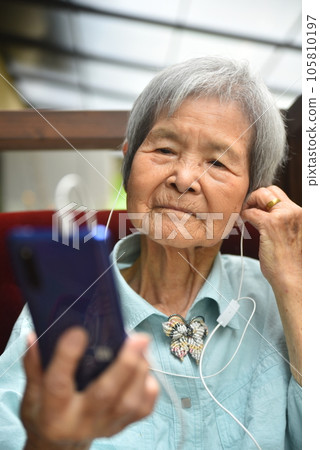 Elderly people listening to music on smartphones 105810197