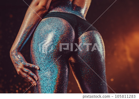 Woman booty with glitter in dark studio Woman booty with glitter in dark studio 105811283