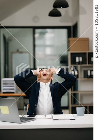 Overworked young Asian businessman office worker suffering from neck pain after had a long day at her office desk. office syndrome concept. Overworked young Asian businessman office worker suffering from neck pain after had a long day at her office desk. office syndrome concept. 105811983