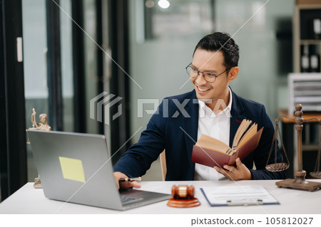 Man lawyer reading legal book with gavel on table in office. justice and law ,attorney concept... 105812027
