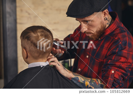 Caucasian boy getting haircut in barbershop indoor 105812669