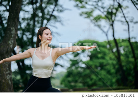 Woman doing warrior pose 2 in yoga outside 105815101