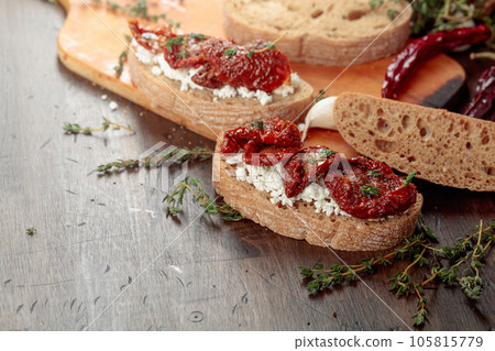 Bruschetta with ricotta, sun-dried tomatoes, and thyme. Bruschetta with ricotta, sun-dried tomatoes, and thyme. 105815779