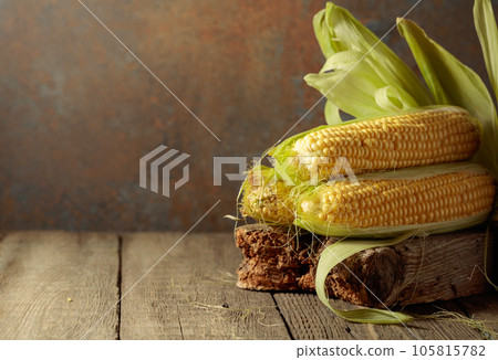 Fresh corn on cobs on a wooden table. Fresh corn on cobs on a wooden table. 105815782