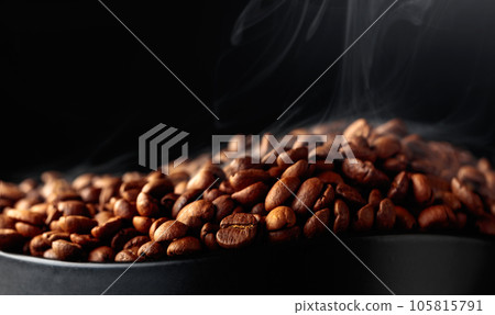 Steaming coffee beans on a black background. Steaming coffee beans on a black background. 105815791