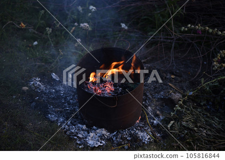 Burning garbage in the tank. Incineration of garbage in an iron bucket. Flames. Burning garbage in the tank. Incineration of garbage in an iron bucket. Flames. 105816844