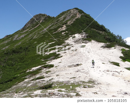 Vertical] A man climbing the gravel slopes of - Stock Photo